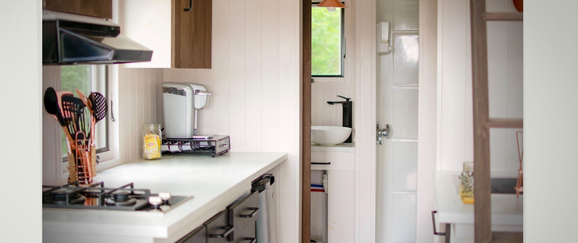 tiny house -inside with kitchen counter, bathroom sink, and ladder