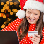teen girl smiling while holding a credit card for kids and shopping online